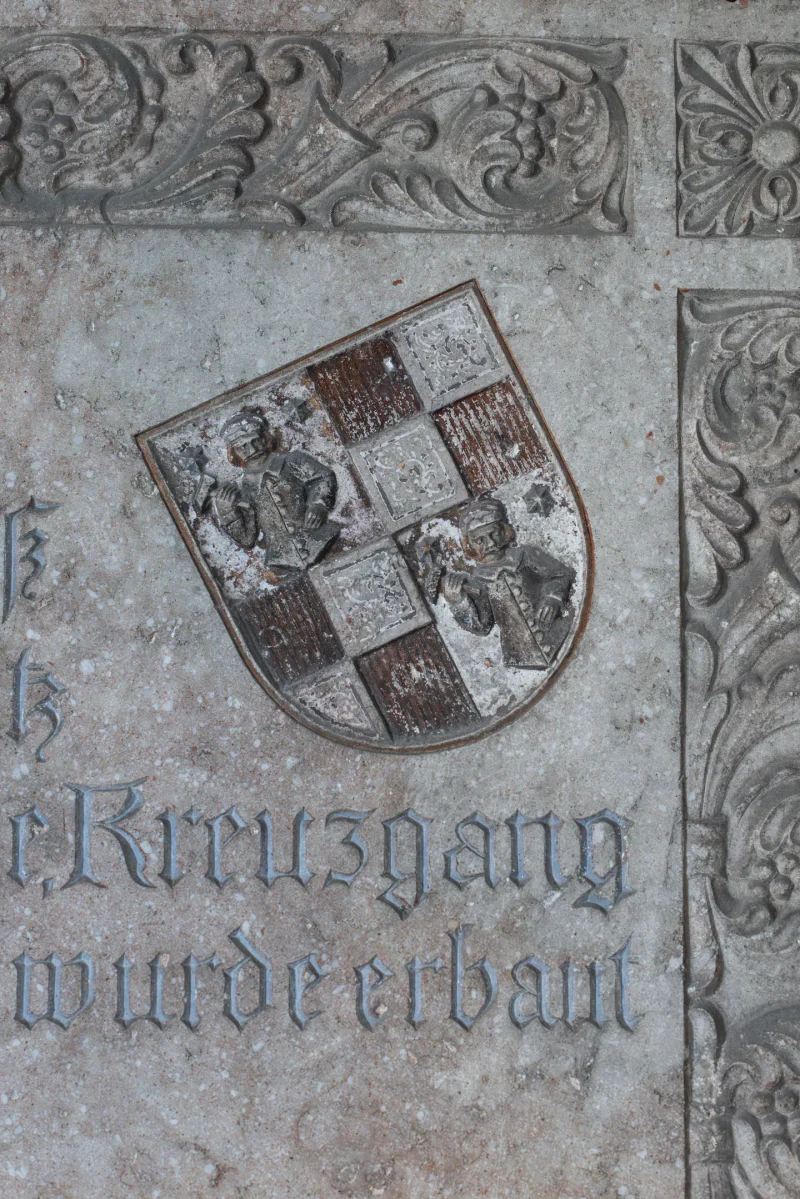 A carved coat of arms and lettering on a stone plaque at the castle.