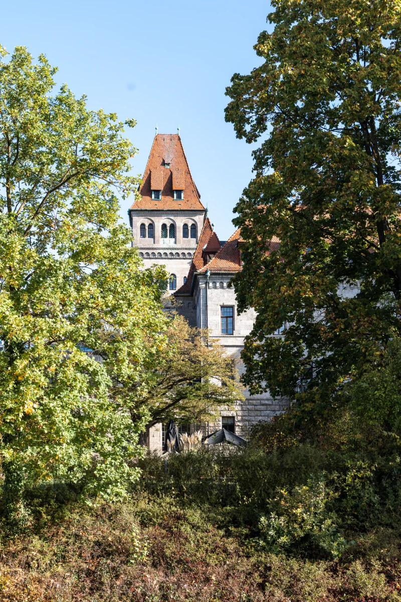 A Faber-Castell castle tower framed by autumn trees.