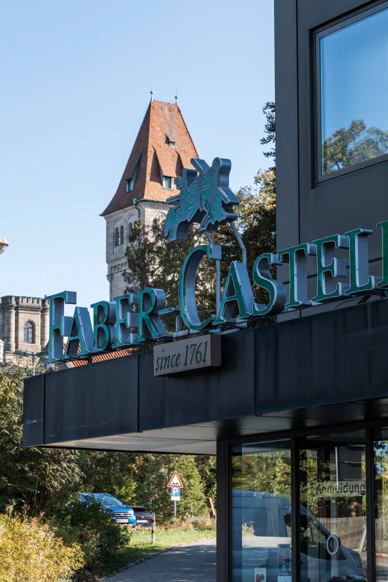 Faber-Castell sign at the entrance, with a castle tower behind it.