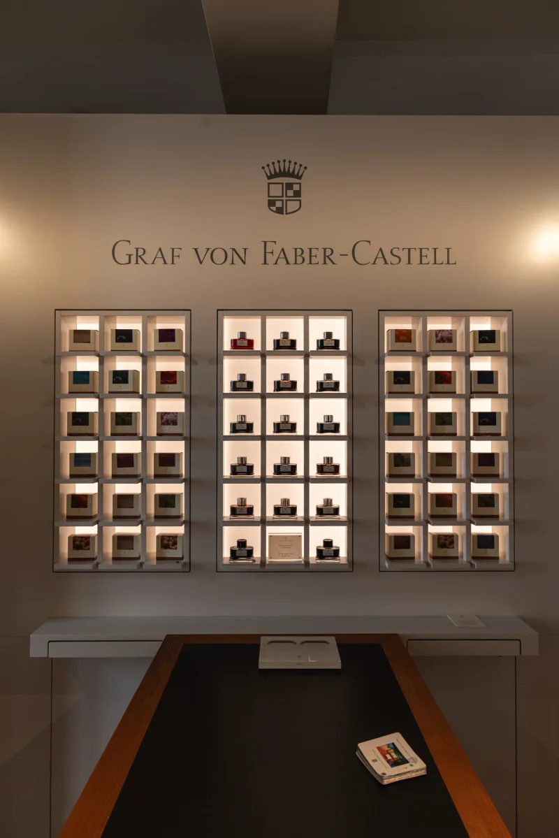 An illuminated Graf von Faber-Castell display of ink bottles and boxes.
