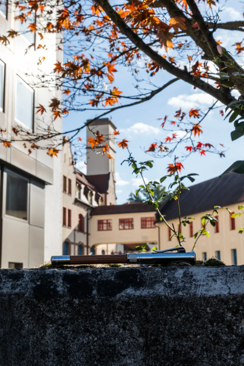 A wood-and-metal Perfect Pencil resting on a wall in the factory courtyard.