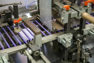Purple Grip pencils with raised dots moving through a Faber-Castell production machine.