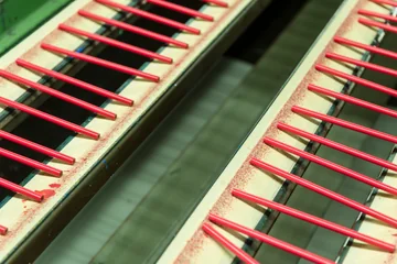 Red lacquered pencils on parallel conveyors at Faber-Castell.