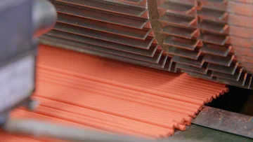 Rows of coloured pencil leads beneath cutting blades at Faber-Castell.