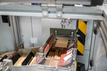 A close-up of shaped wooden pencils leaving a machine at Faber-Castell.