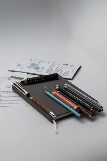 Faber-Castell pencils resting on a grey Graf von Faber-Castell notebook on my desk.