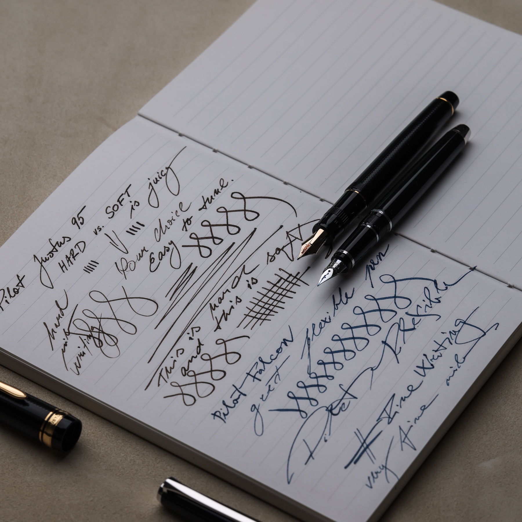 Pilot Falcon and Pilot Justus 95 resting on handwritten line-variation tests