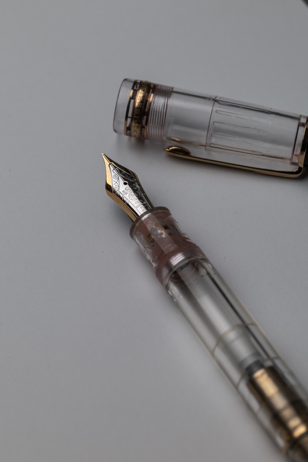 Close-up of the Montblanc Meisterstück 149 Demonstrator two-tone 18K gold nib, pink-toned nib housing and transparent cap