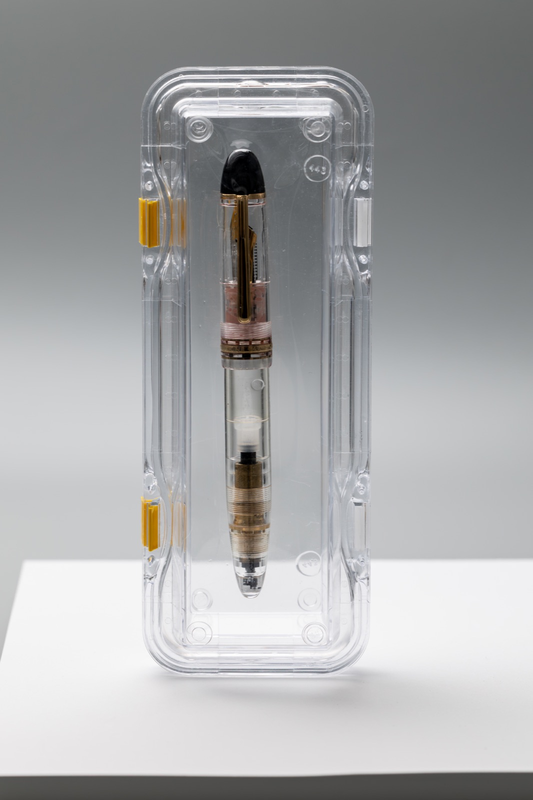 Front view of the capped Montblanc Meisterstück 149 Demonstrator inside a clear protective case with yellow latches