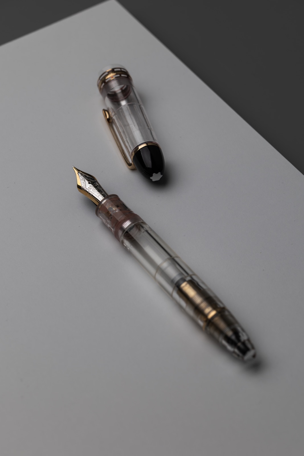 Montblanc Meisterstück 149 Demonstrator uncapped, showing its transparent barrel, visible piston mechanism and black cap top