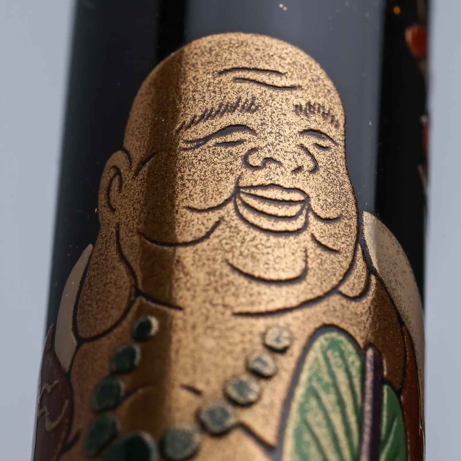 Hotei-son's smiling face rendered in gold maki-e on the Namiki Yukari fountain pen