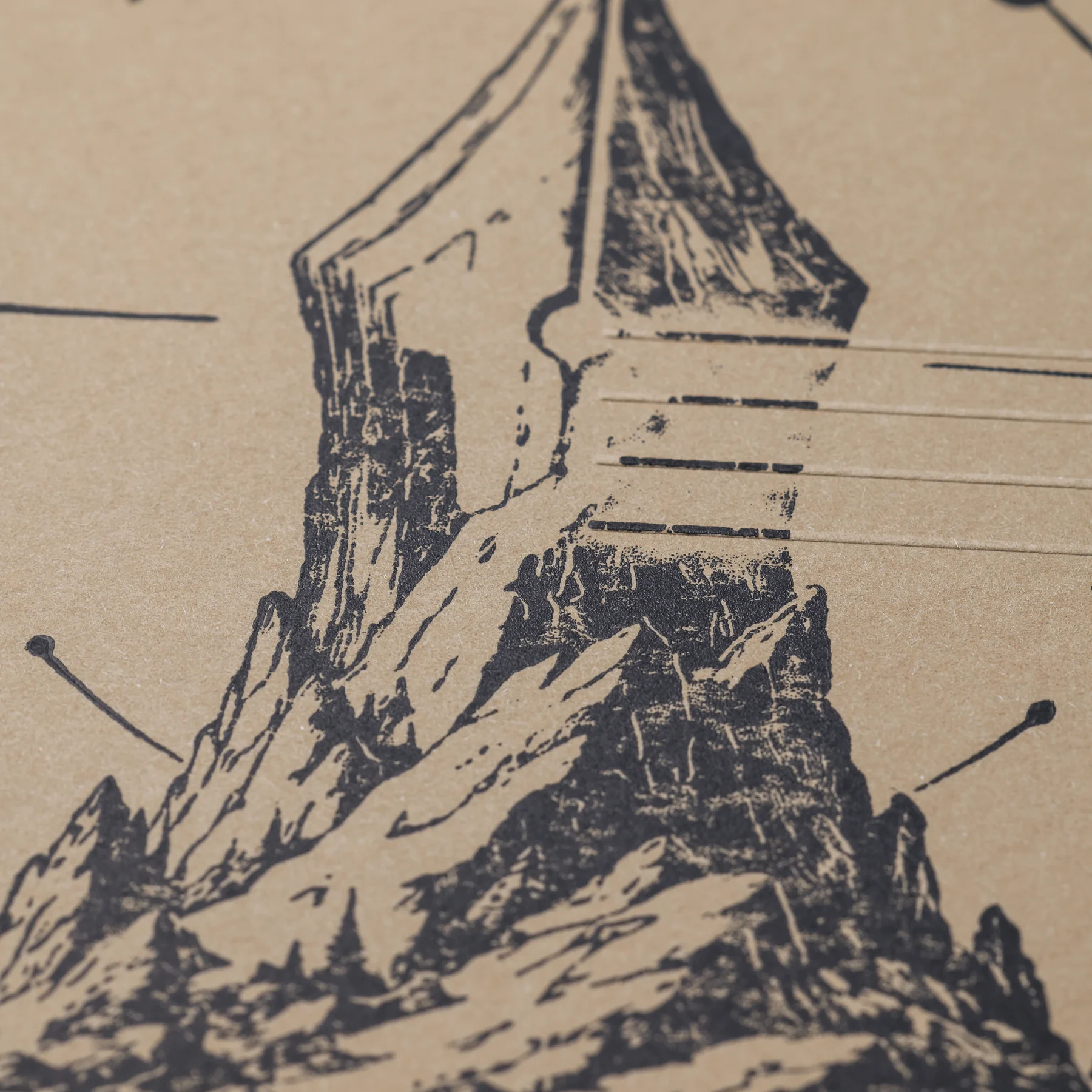 Close-up of the mountain and lower fountain pen nib in the black linocut artwork on the ASCENT cover