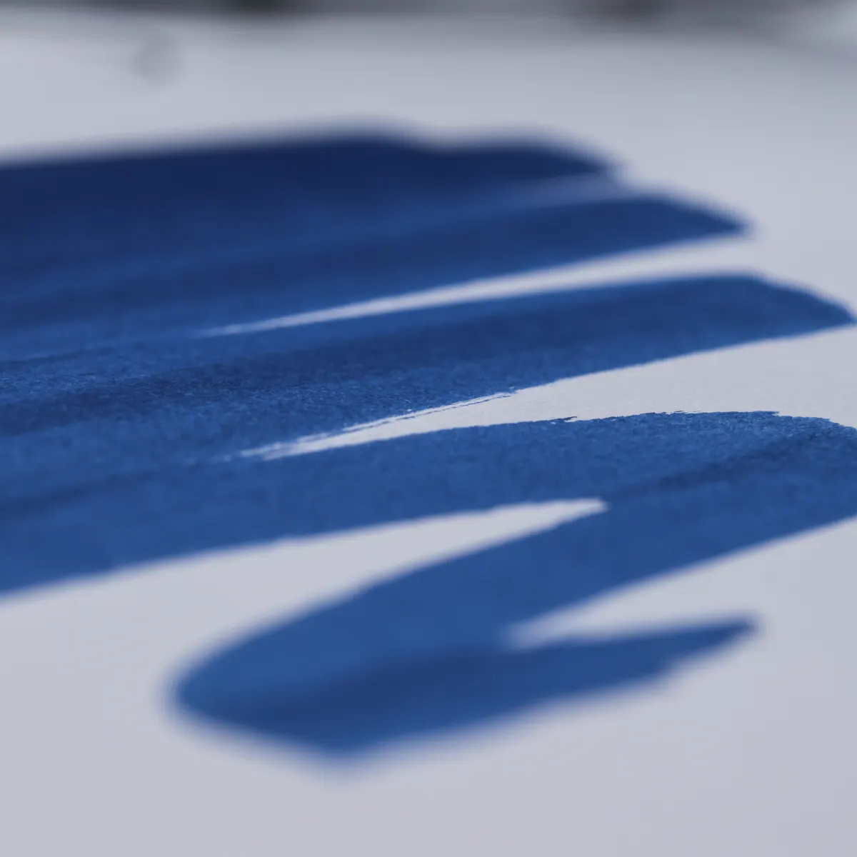 Close-up of broad blue ink swatches and their edges on white FMP Script 150 paper