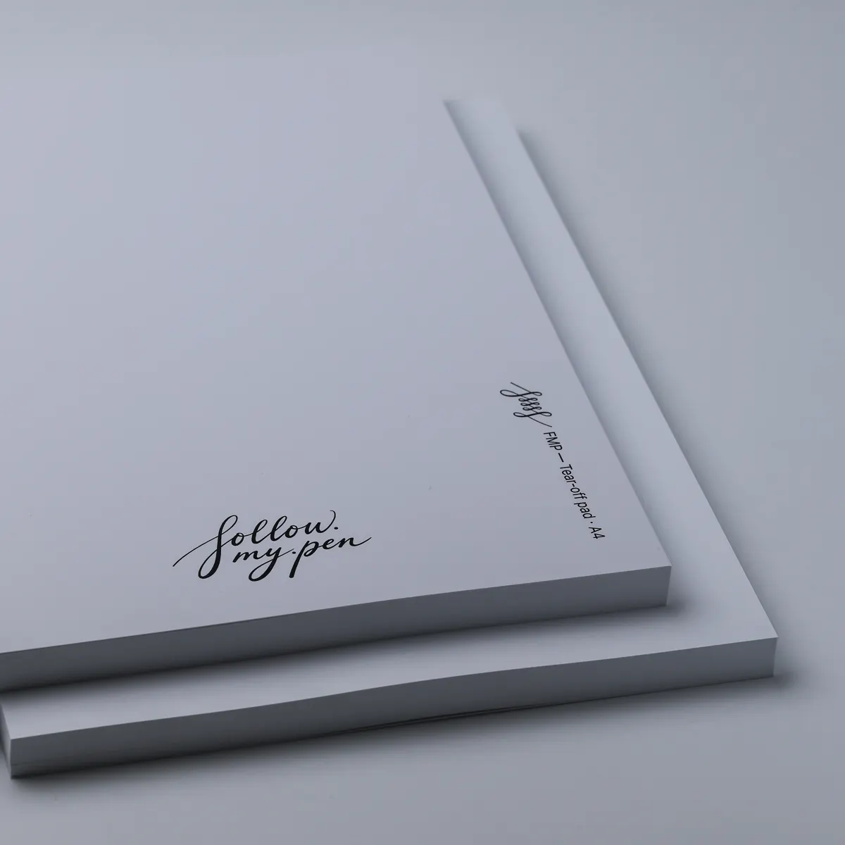 Two stacked white FMP A4 tear-off pads with Follow My Pen branding and visible sheet edges
