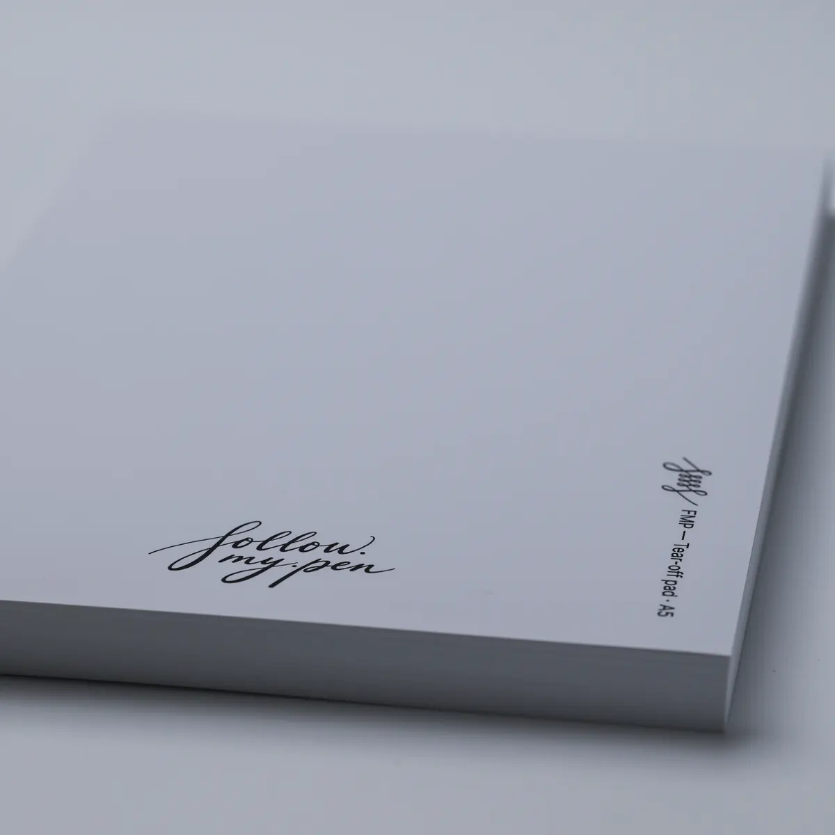 Close-up of the Follow My Pen logo, A5 label and sheet edges on an FMP tear-off pad