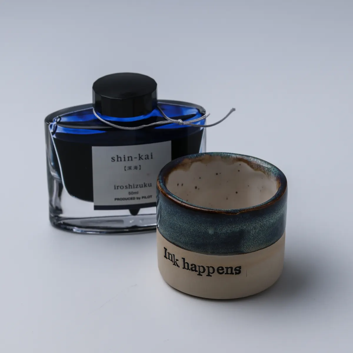 Elevated view of the mug’s cream interior beside a blue Shin-kai ink bottle