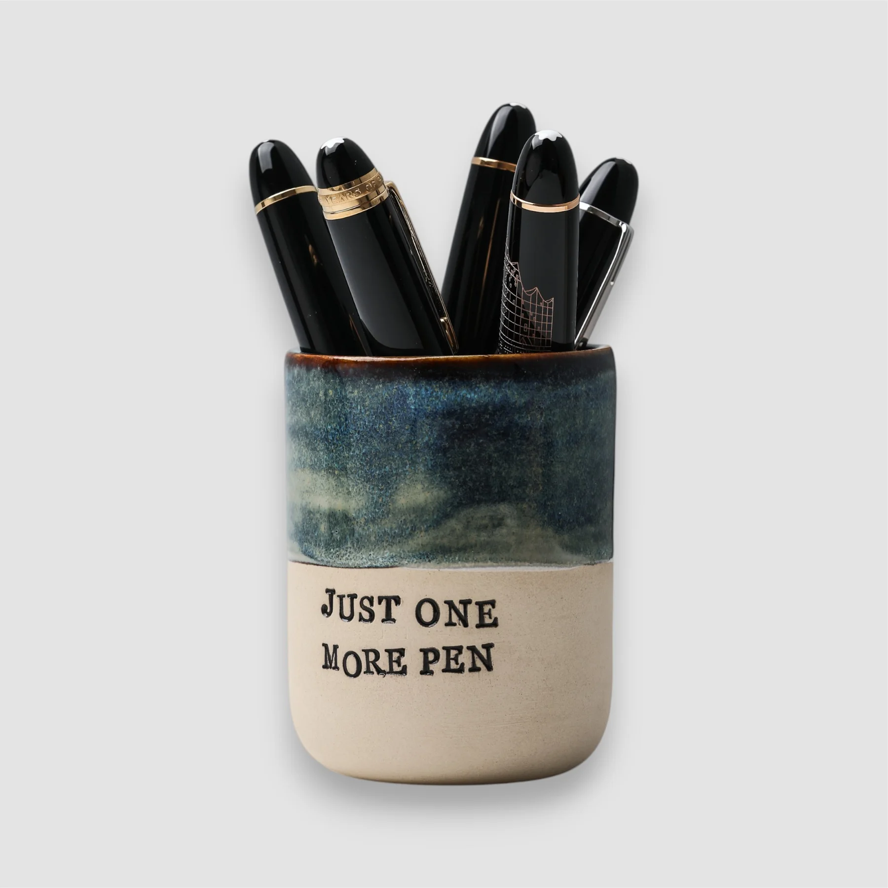 Handmade Just One More Pen ceramic cup with blue glaze, natural clay base and fountain pens inside