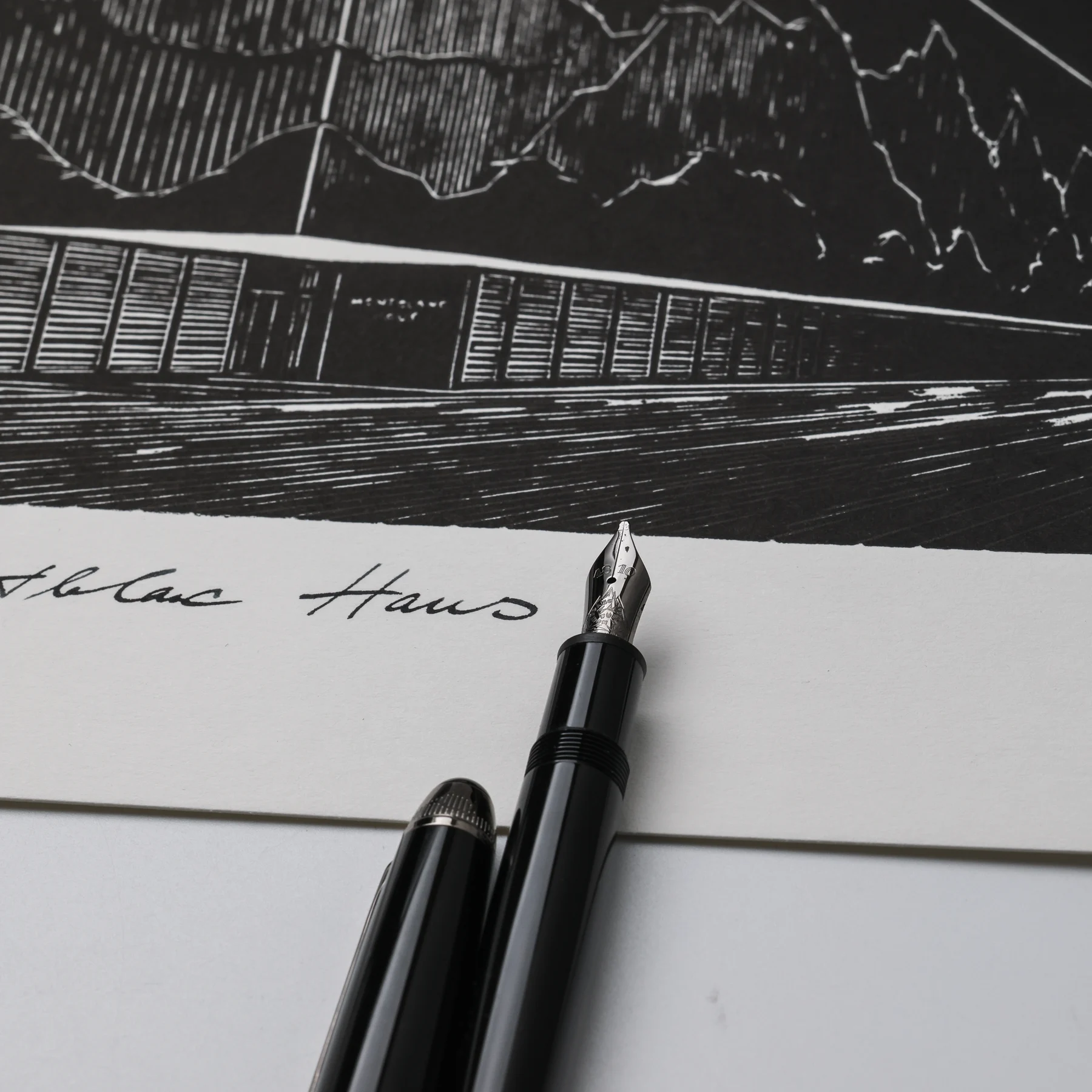 Close-up of the Montblanc Haus linocut entrance and handwritten title beside a fountain pen nib
